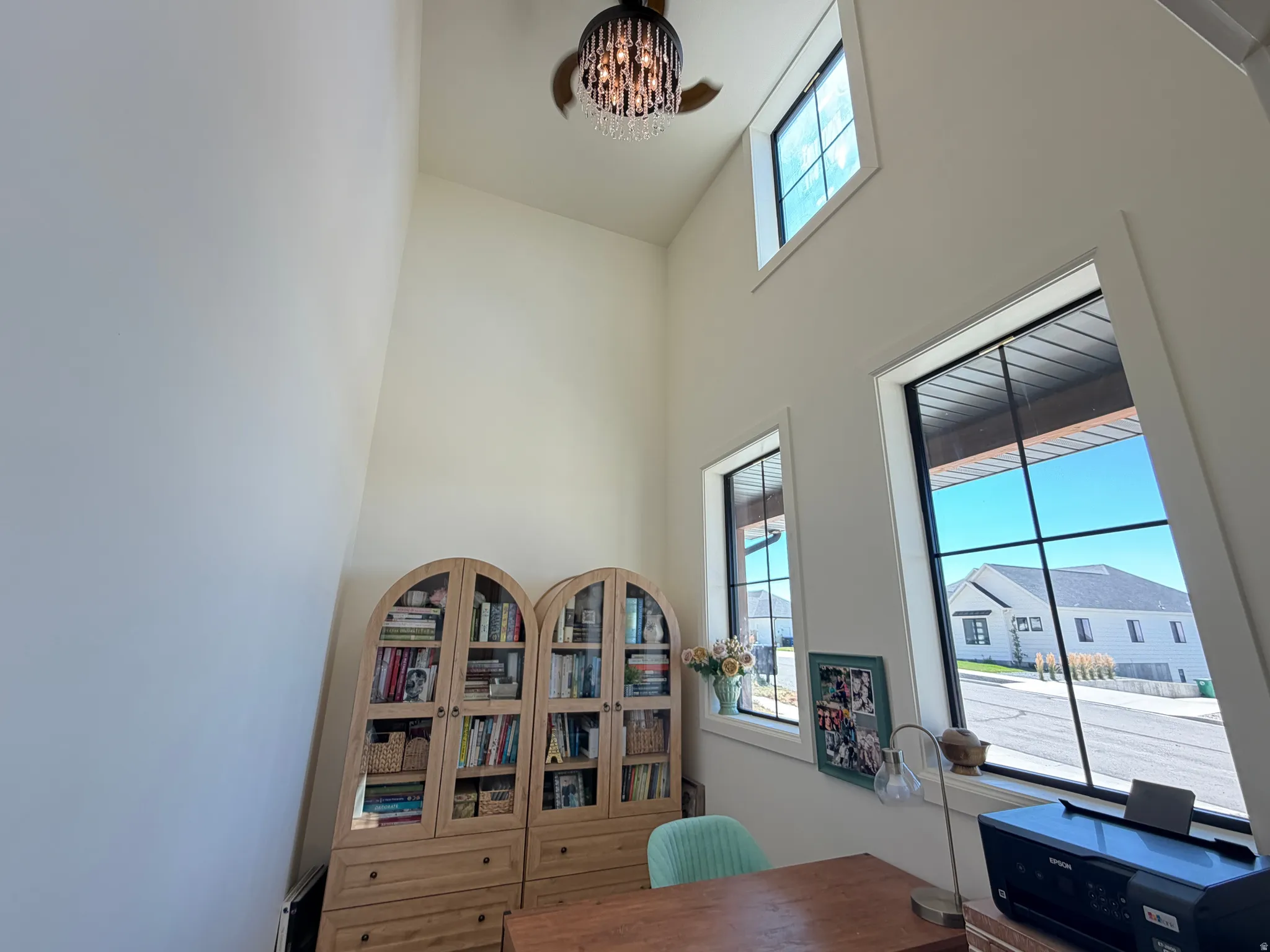 Vaulted ceiling featuring a decorative chandelier and multiple windows
