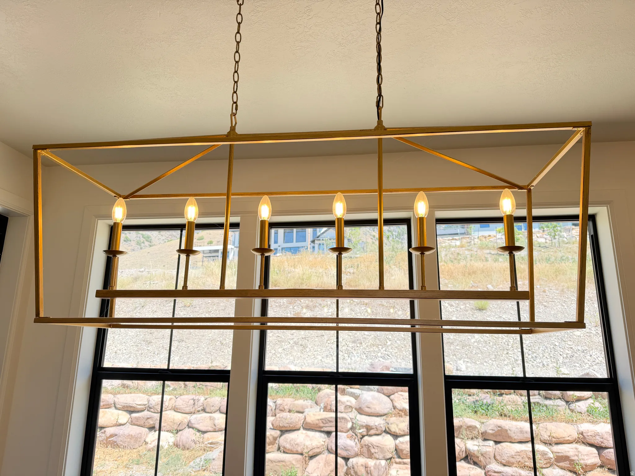 Geometric chandelier with a gold-tone finish, featuring six candelabra-style lights
