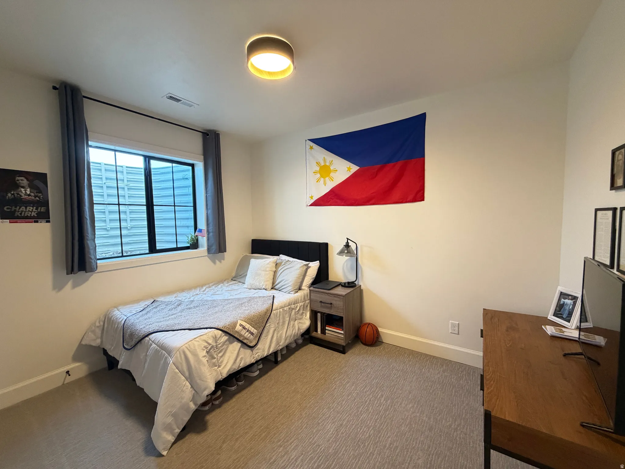 Bedroom 5 featuring a window with black trim, gray carpet flooring, and white walls