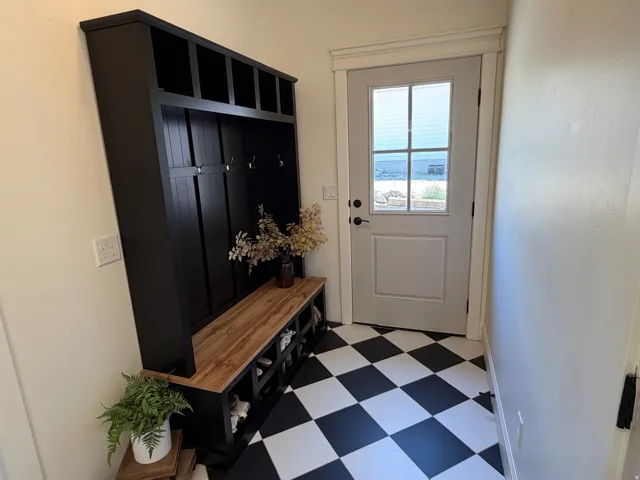 Built-in black mudroom unit with a wood-finish bench and cubby storage, Entry from the South.