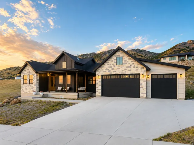 Timeless French farmhouse exterior featuring stone accents and dark vertical stone siding