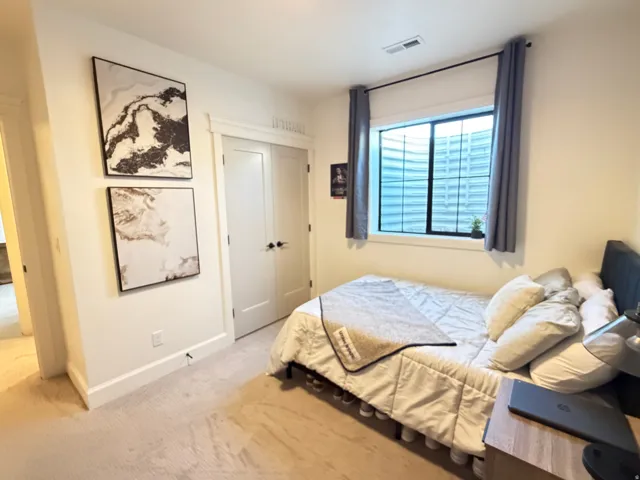 Bedroom 5, carpeted room featuring a double-door closet, a single window, and white trim