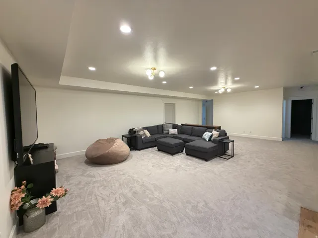 Spacious room featuring light-toned carpeting and recessed ceiling lights