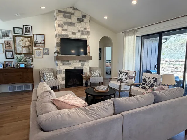 Living area featuring a floor-to-ceiling stone fireplace with a wood-finish mantel and integrated firebox