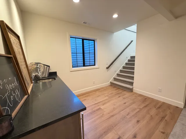 Built-in wet bar with dark countertop and stainless steel sink