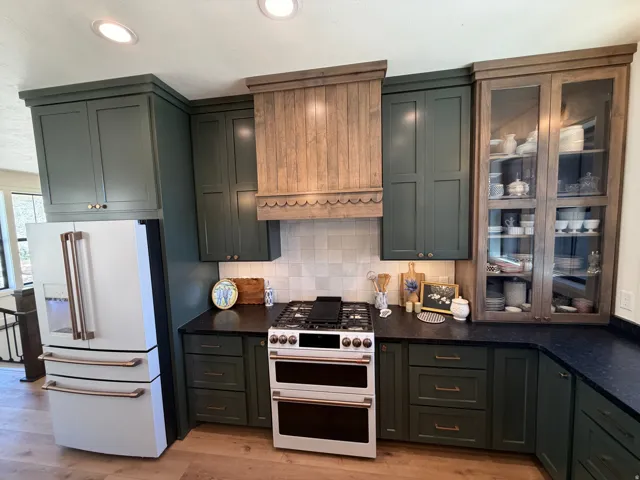 Kitchen featuring recessed lighting, dark green cabinetry, black countertops, and a tile backsplash
