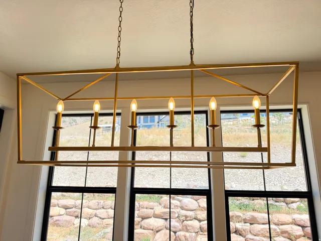 Geometric chandelier with a gold-tone finish, featuring six candelabra-style lights