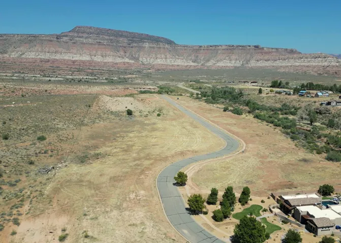 Expansive desert landscape with a paved road winding through undeveloped land