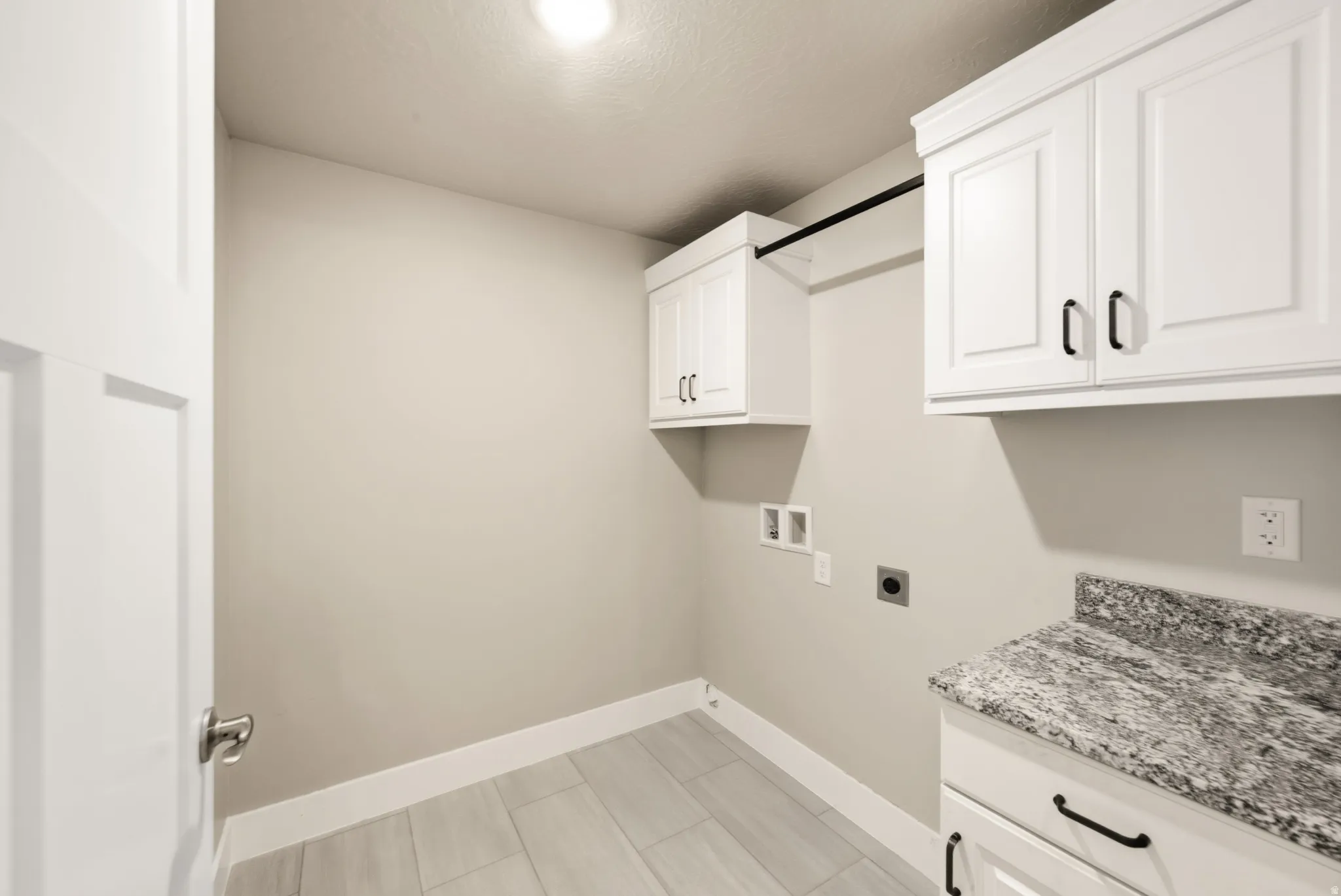 Dedicated utility space featuring light-toned plank-style flooring