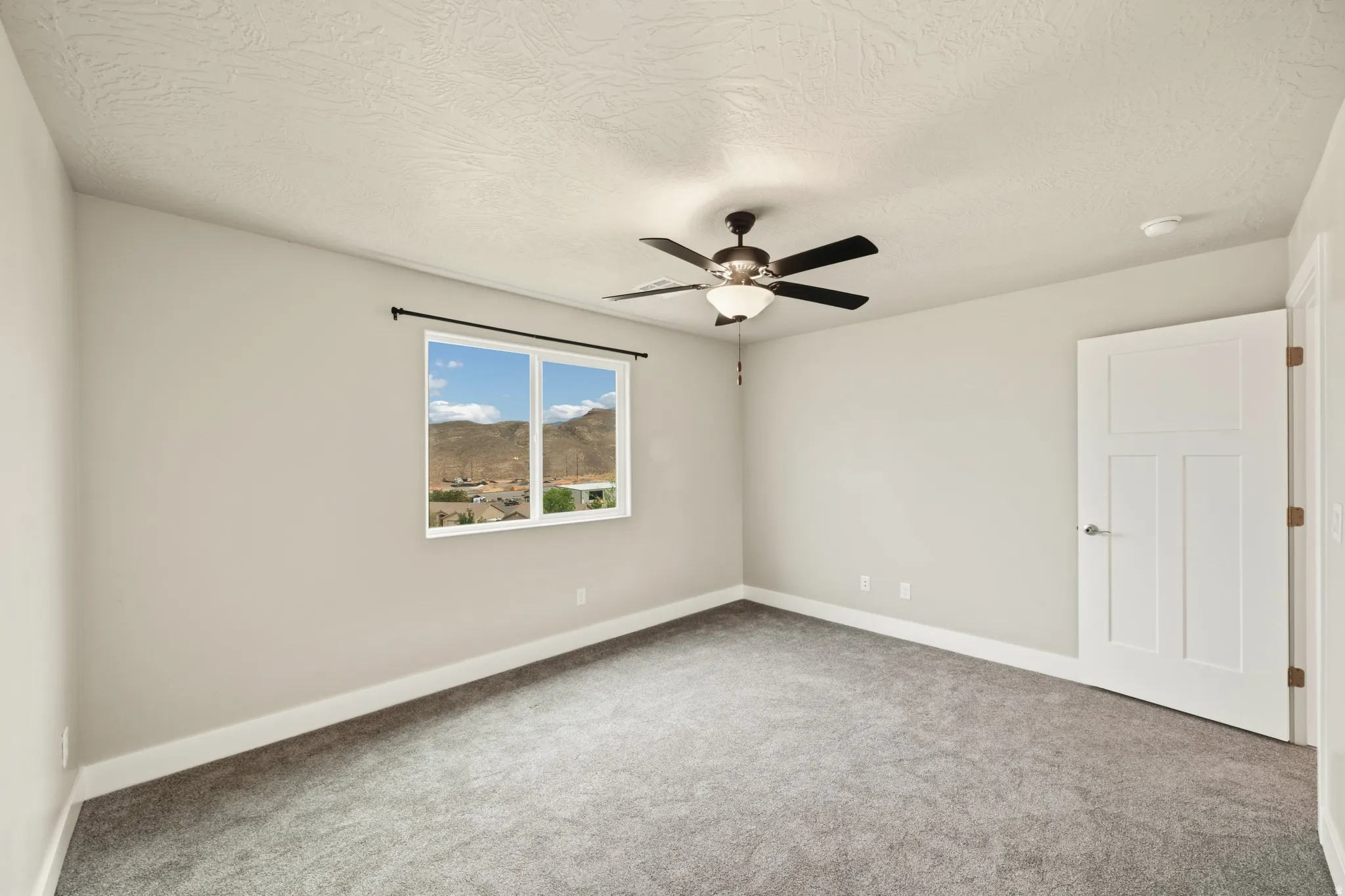 Spacious room featuring gray carpet, light neutral wall paint, and white trim