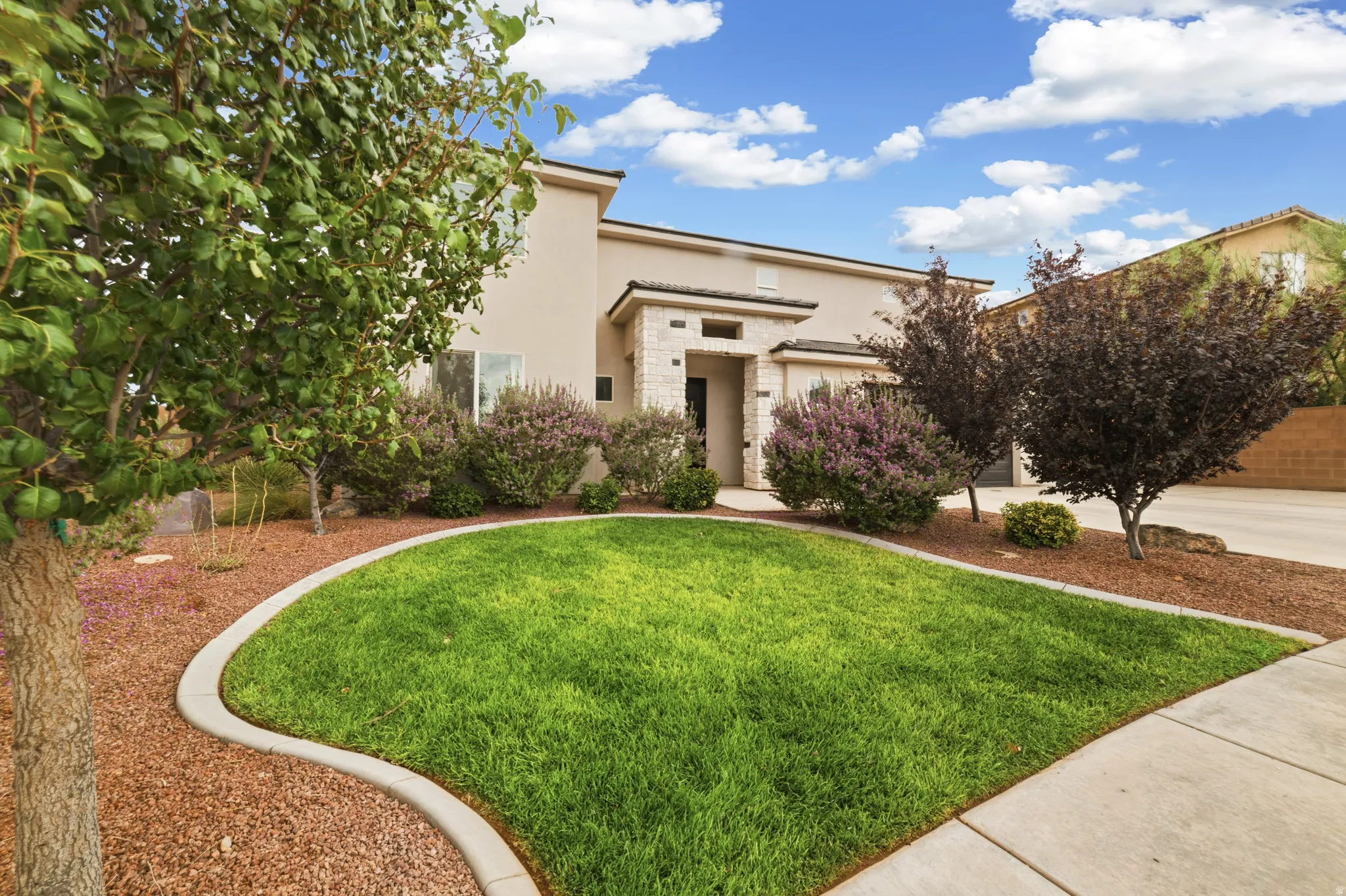 Stucco exterior with stone accents and a concrete walkway