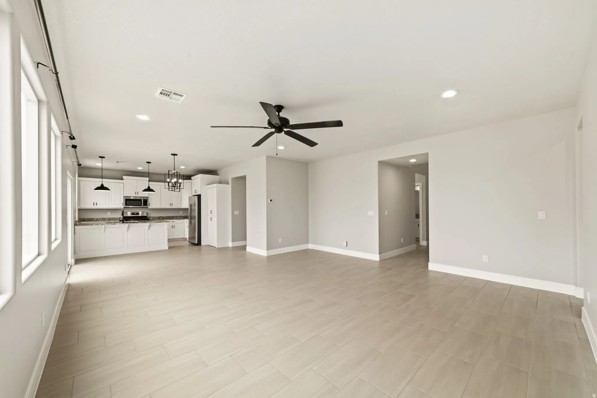 Open-concept living space featuring wood-finish flooring, recessed lighting, and a contemporary ceiling fan