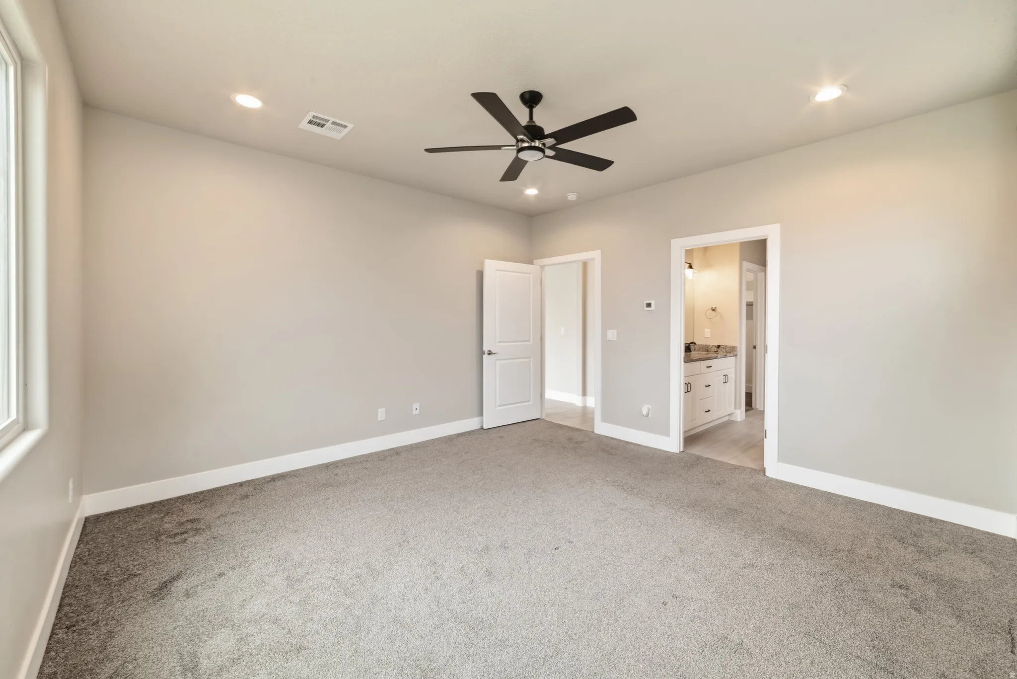 Spacious room featuring neutral carpeting and light gray walls