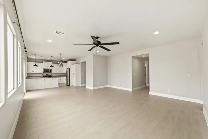 Open-concept living space featuring wood-finish flooring, recessed lighting, and a contemporary ceiling fan