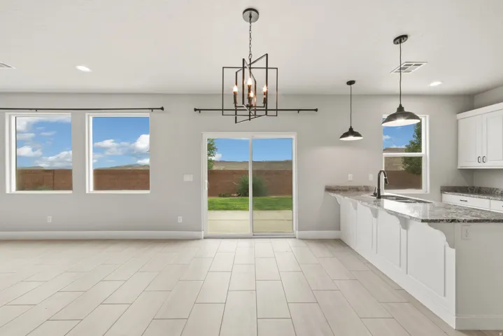 Open-concept living area featuring light wood-finish plank flooring, recessed lighting, and a modern geometric chandelier