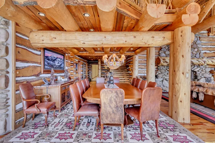 Expansive dining area featuring a long wooden table, a tiered chandelier, and recessed lighting