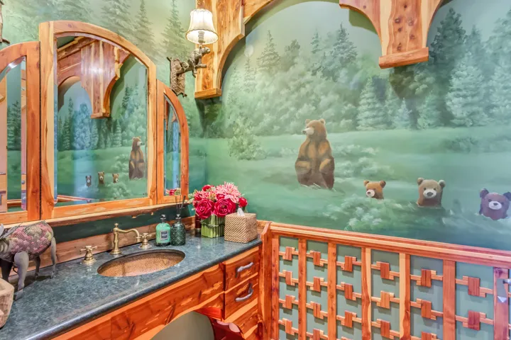 Custom-painted mural featuring a forest and bears, complemented by a wood-finish vanity with a copper vessel sink