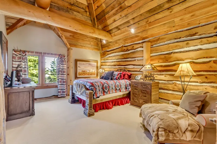 Vaulted wood-paneled ceilings with exposed beams, wood-plank walls, and dual window openings