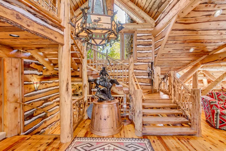 Expansive log home interior featuring natural wood walls and exposed beam ceilings