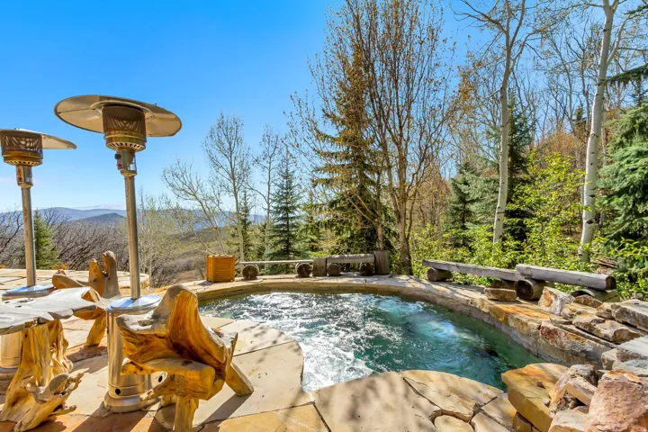 Outdoor hot tub with natural stone surround and integrated seating