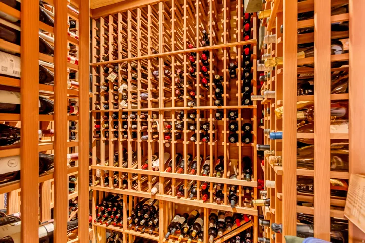 Custom-built wine cellar featuring extensive light wood racking, accommodating a substantial bottle collection