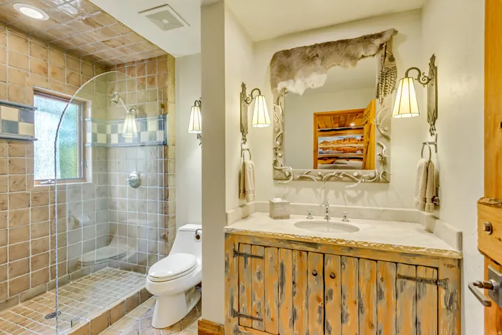 Bathroom featuring a walk-in shower with glass enclosure, tiled walls, and a window