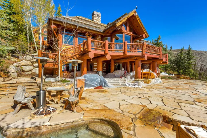 Expansive flagstone patio featuring a built-in outdoor pool and spa
