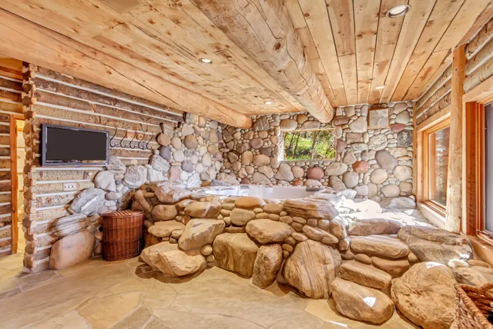 Stone-lined spa area featuring a built-in hot tub