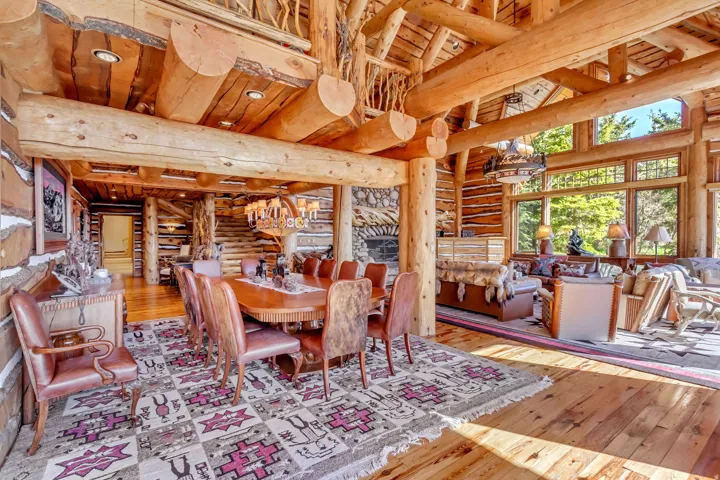 Expansive open-concept living area featuring a prominent log and beam ceiling