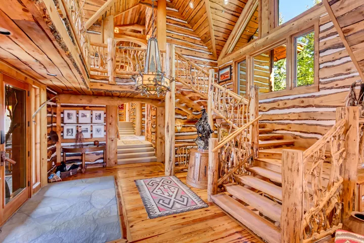 Grand lodge-style interior featuring natural wood log walls and ceilings