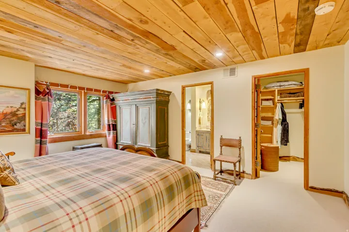 Recessed lighting illuminates a wood-planked ceiling, complementing the wood window frames and trim