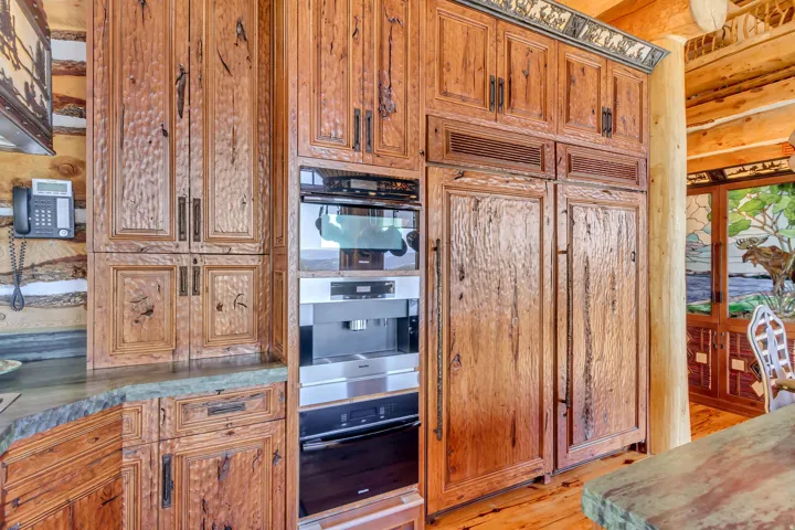 Built-in appliances integrated into custom wood cabinetry with textured panels and dark hardware
