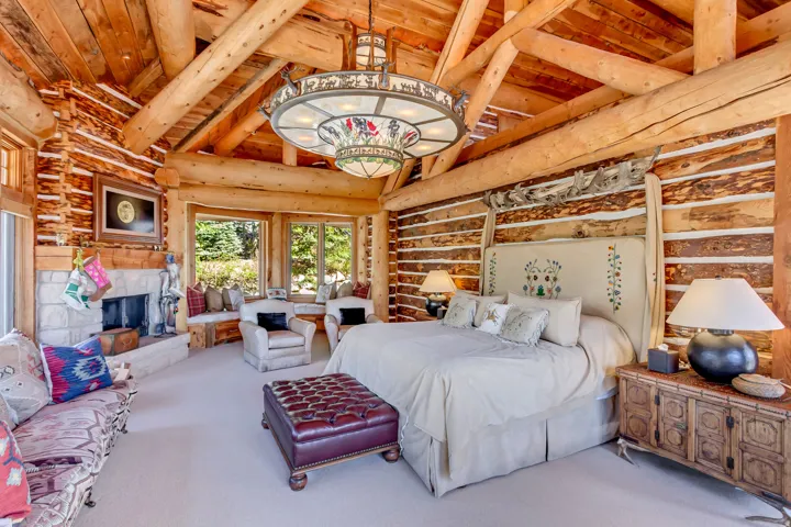 Vaulted wood-beam ceilings over a spacious room with log wall construction