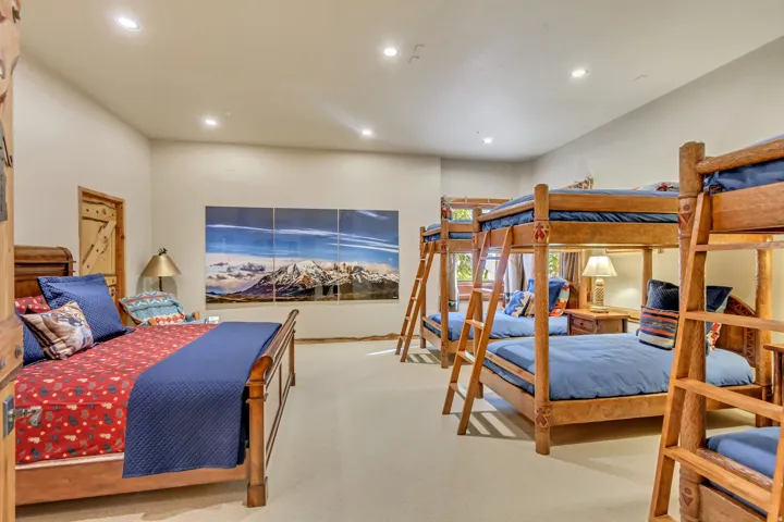 Spacious room featuring multiple wood-frame bunk beds and a single sleigh bed