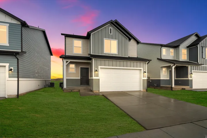 Two-story residence featuring a gray and beige exterior with board and batten accents