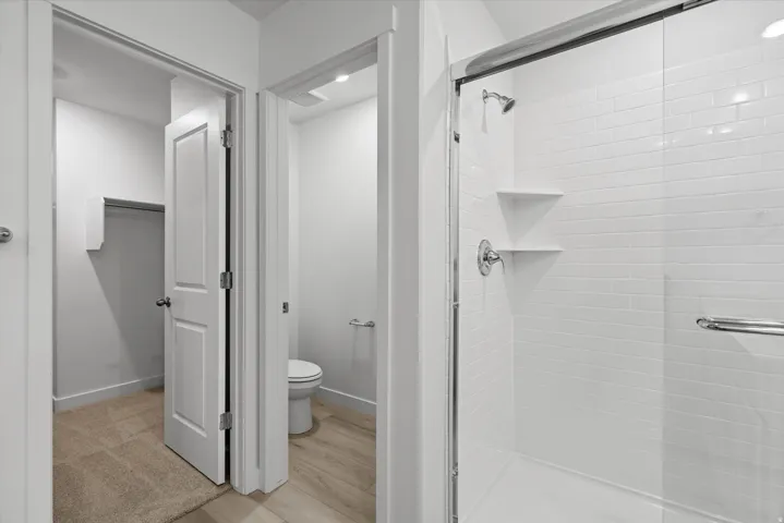 Walk-in shower with clear glass enclosure and white subway tile surround