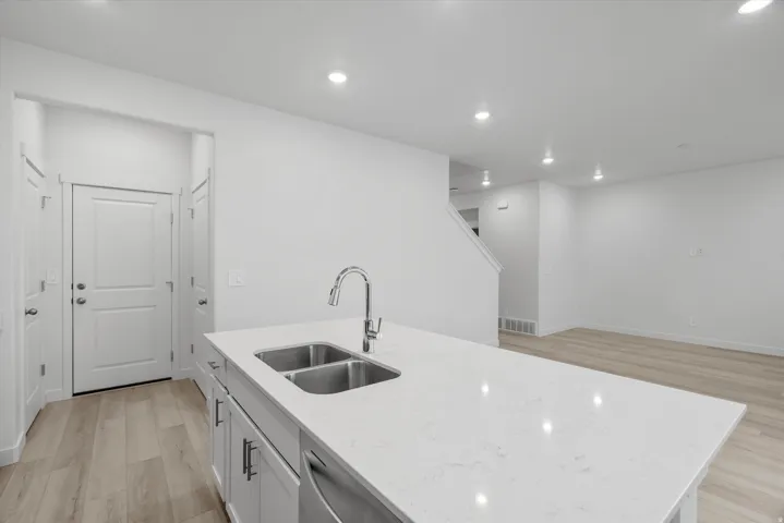 Kitchen island with a quartz countertop and stainless steel double basin sink