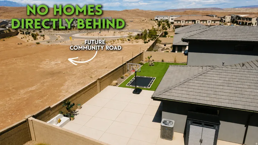Expansive paver patio with a turf area and a block perimeter fence