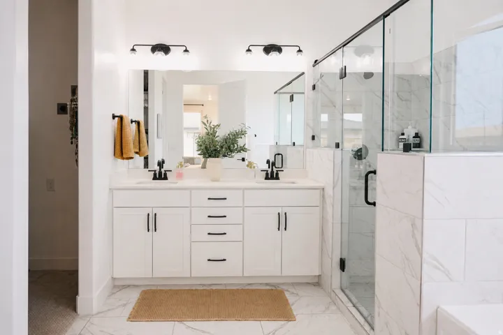 Dual vanity with white cabinetry, matte black hardware, and undermount sinks