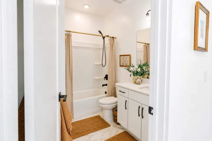 White vanity with black hardware, white countertop, and integrated sink