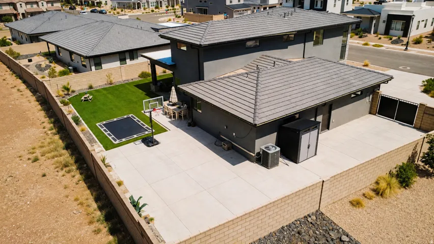 Expansive concrete patio, lush green lawn, and a covered outdoor living area