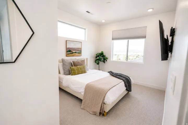 Recessed lighting, wall-mounted television, and carpeted flooring