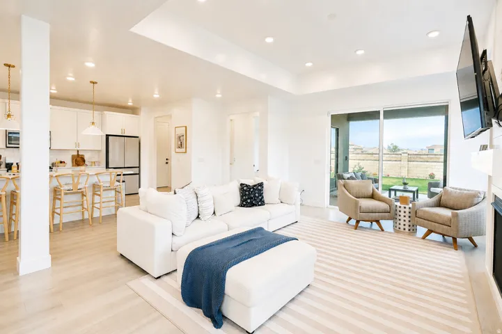 Recessed lighting, wood-finish flooring, white cabinetry, stainless steel refrigerator, and glass sliding doors