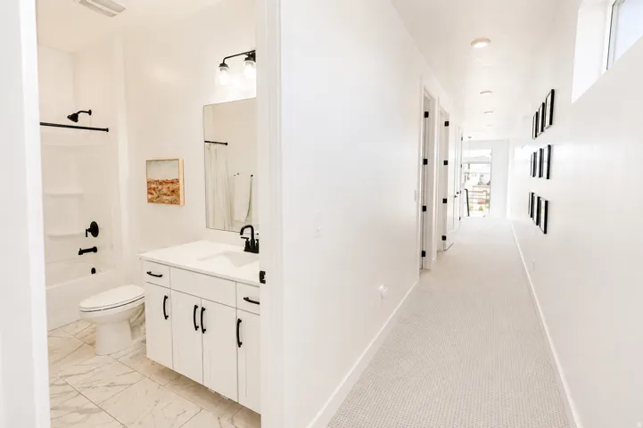 Bathroom featuring white vanity with black hardware, white countertop, and tile flooring