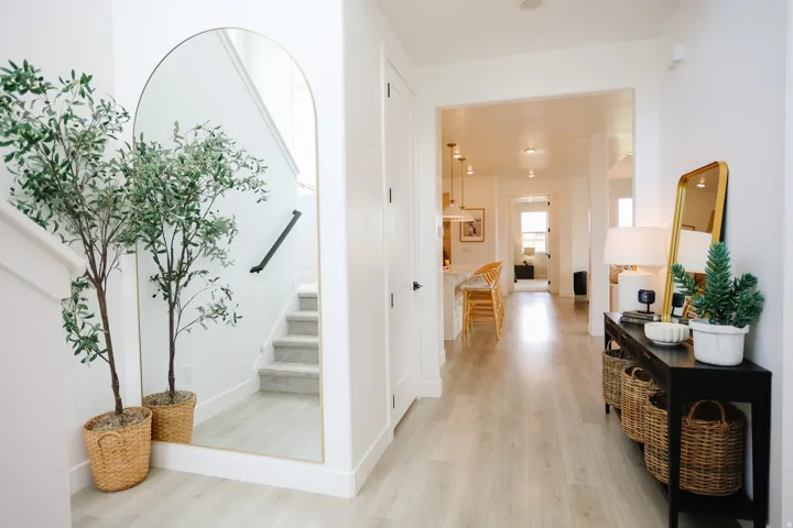 Bright, open hallway flooded with natural light, featuring light wood-finish flooring throughout