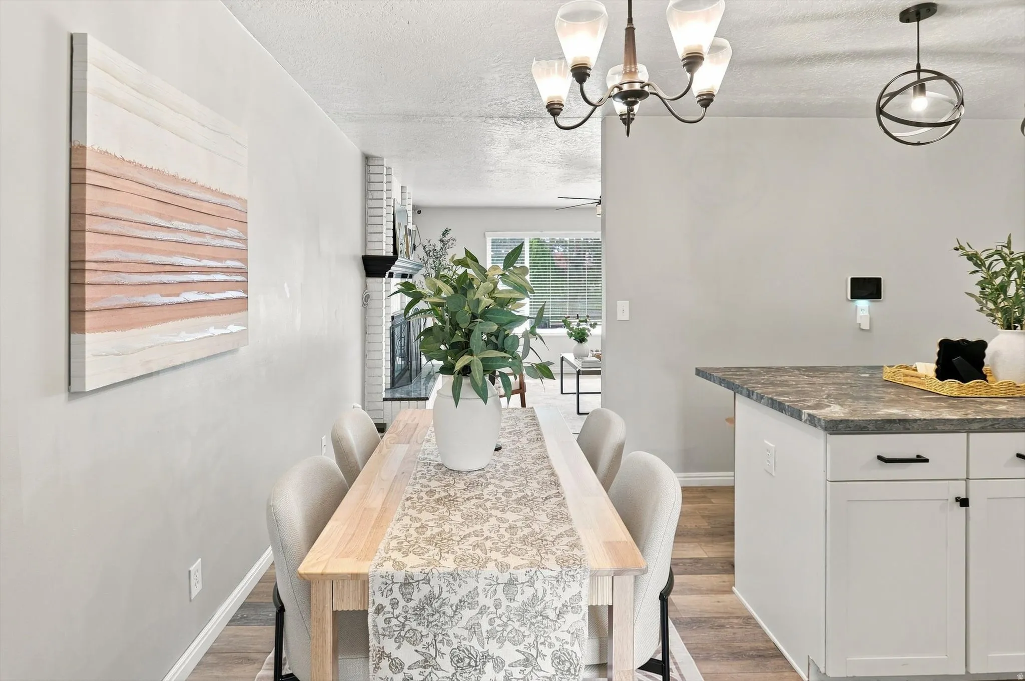 Dining area with wood-finish flooring and a contemporary chandelier