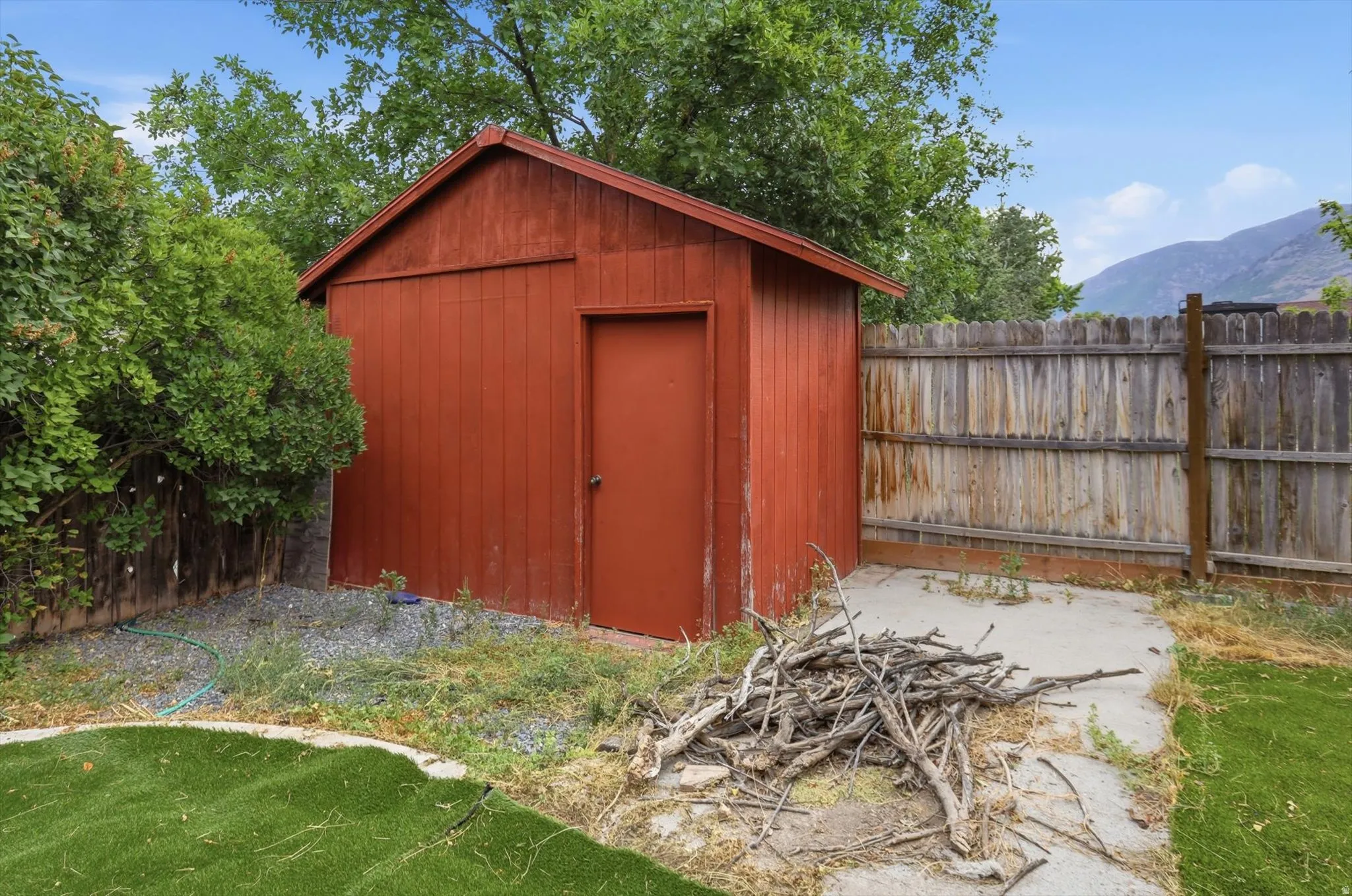 Red painted storage shed with a gabled roof