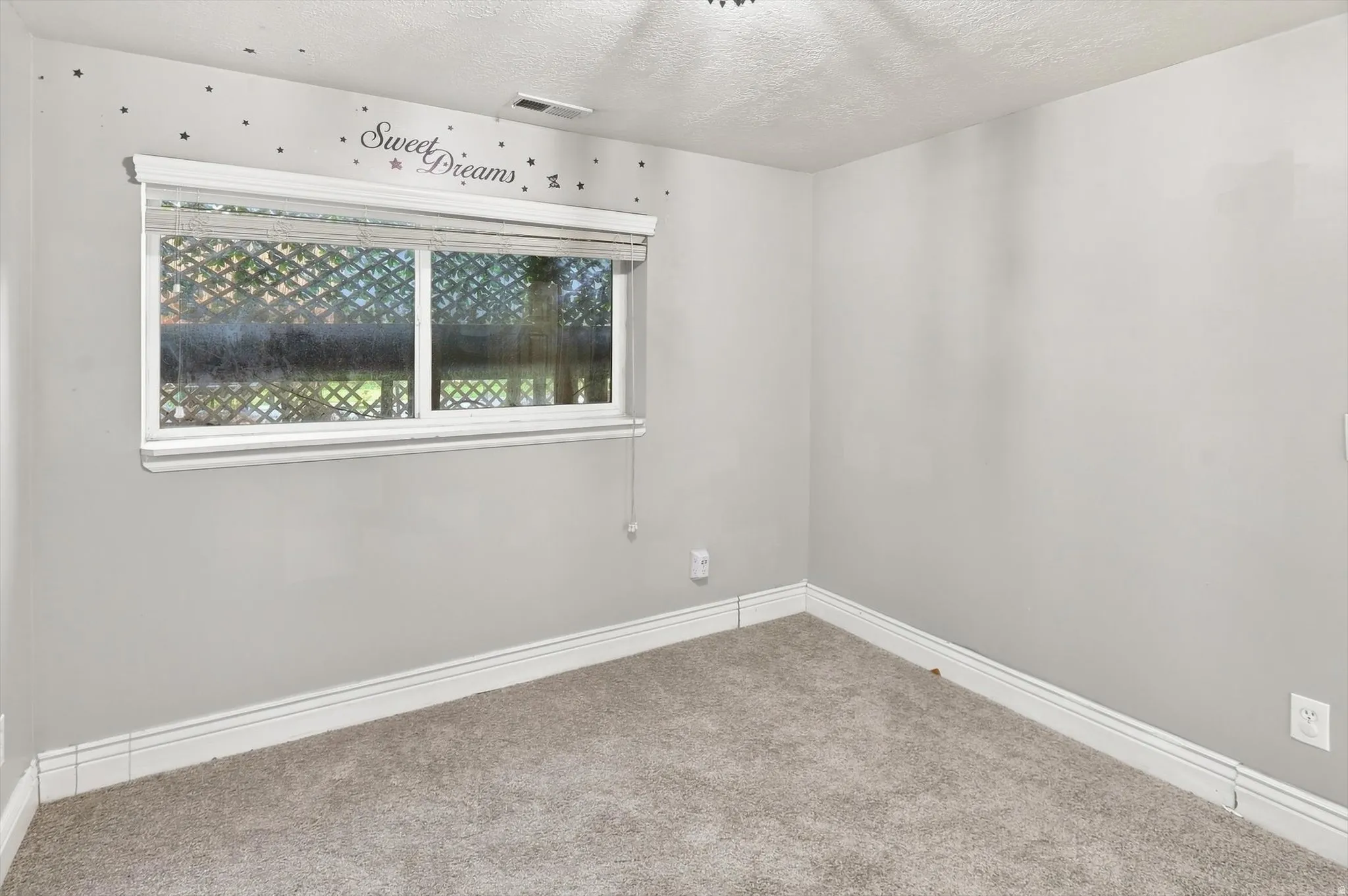 Light grey painted walls with white trim and a window featuring blinds