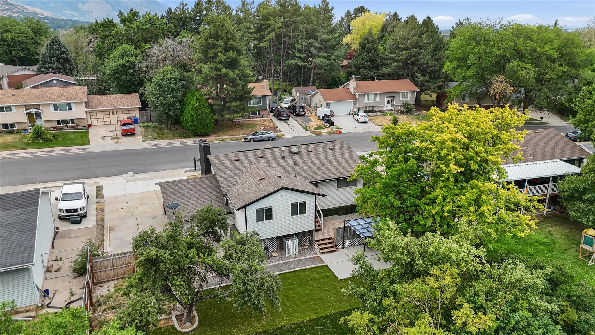 Contemporary two-story residence featuring a gray exterior and dark shingle roof