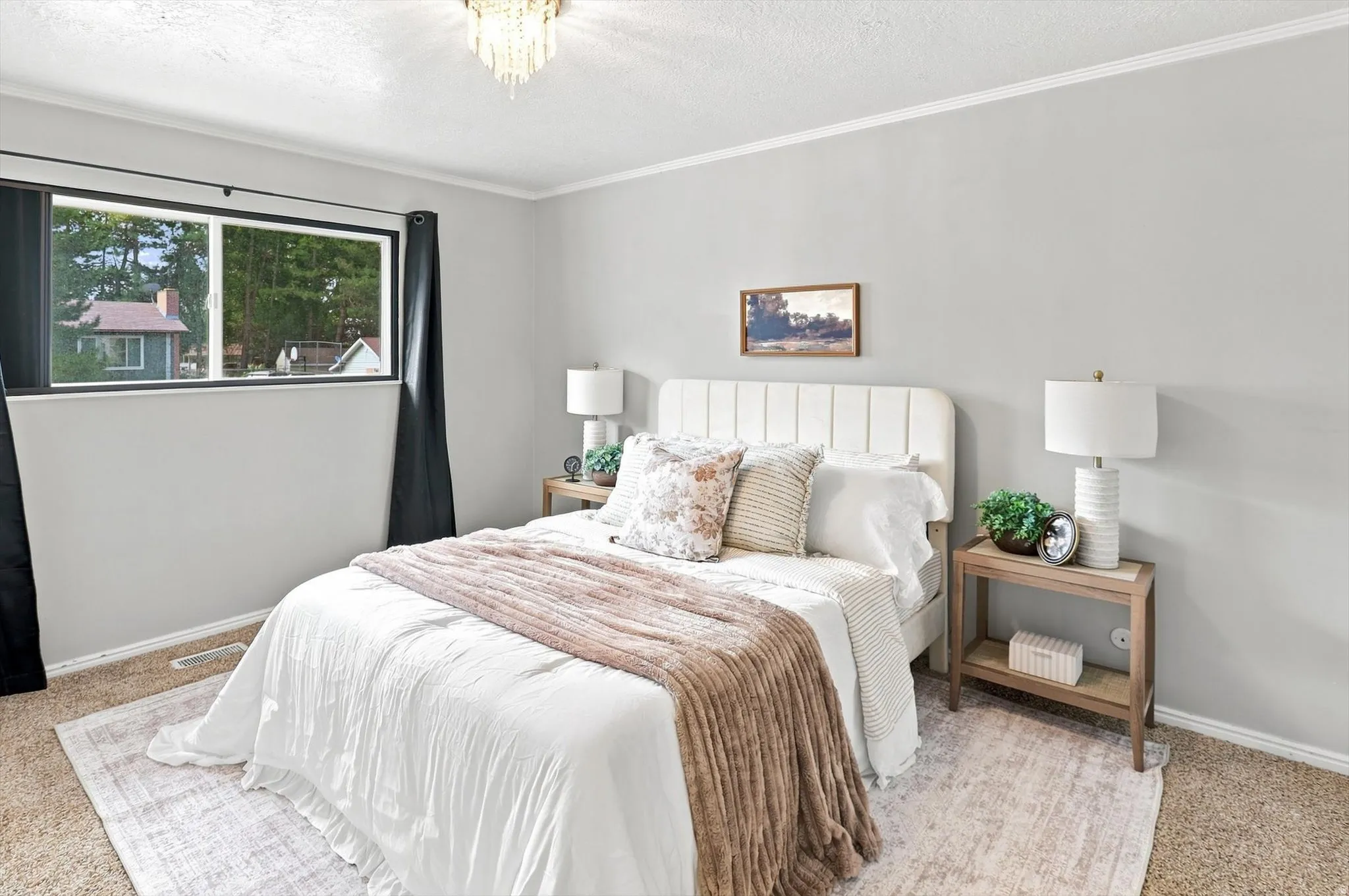Bedroom featuring light-toned walls, crown molding, and carpeting